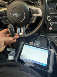 An automotive locksmith coding a new Ford Mustang key