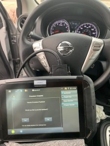 Automotive locksmith coding a new Nissan key fob replacement on-site
