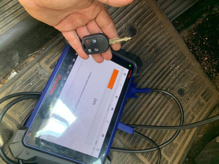 Auto locksmith coding a new transponder key with a special coding tool