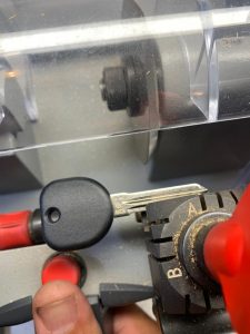 Automotive locksmith cutting a new car key