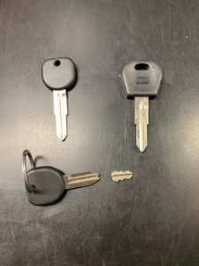 Broken car key pieces and replacement keys