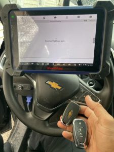 An automotive locksmith is coding a new Chevy key fobs.