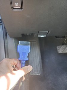 Automotive locksmith is connecting the coding machine to the car's obd to program new Mitsubishi keys