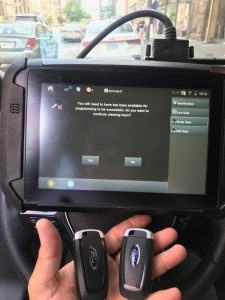 Automotive locksmith coding a new Ford key fobs on-site