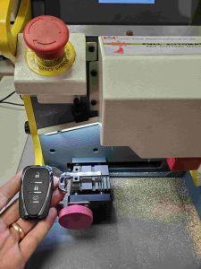 Automotive locksmith is cutting a Chevy key fob emergency key