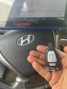 An automotive locksmith coding a new Hyundai key fob on-site