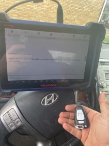 Automotive locksmith coding a new Hyundai Veracruz key fob on site