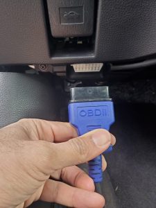 Automotive locksmith is connecting the coding machine to the car's obd to program new Mitsubishi keys