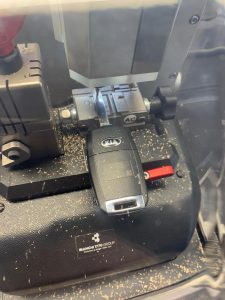 Automotive locksmith cutting a new Kia key
