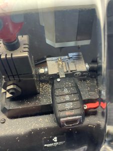 Automotive locksmith cutting a new transponder key on-site