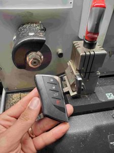Automotive locksmith is cutting a Lexus key fob emergency key