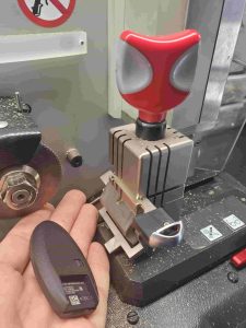 New Infiniti key fob on a computer operated cutting machine