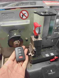 Automotive locksmith is cutting a Toyota key fob emergency key