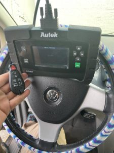 An automotive locksmith coding a new Volkswagen key fob on-site