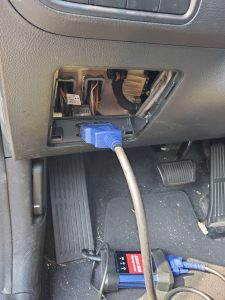 Automotive locksmith is connecting the coding machine to the car's obd to program new keys