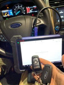 An automotive locksmith coding a new Ford key fob on-site